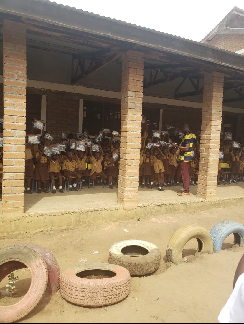 Pupils at a school in Sierra Leone holding up their hygiene packages