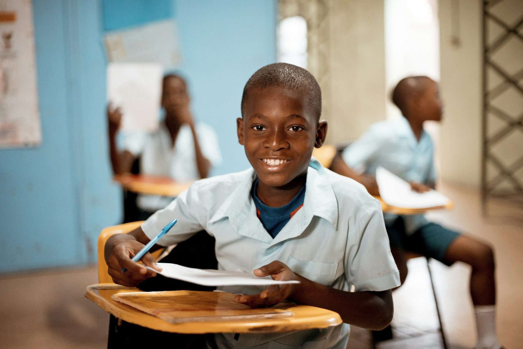 A smiling schoolboy at his desk